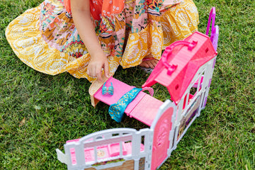 girl playing a mini barbie bedroom set