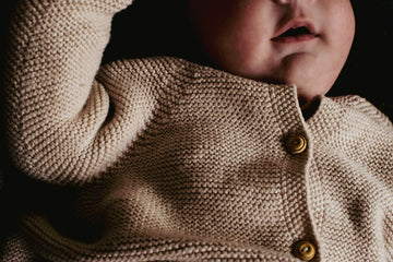 Baby in his comfy baby romper which is grey