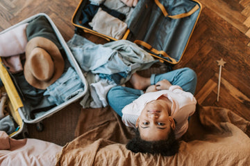 kid sitting on the floor beside luggage