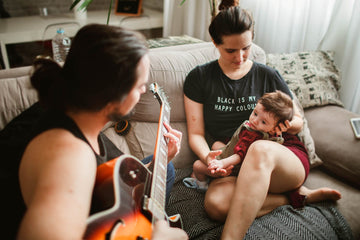 Father singing to baby in his mother hands