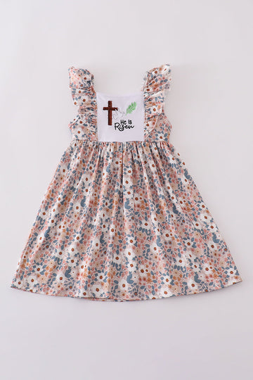 Pink Easter dress with "He is Risen" embroidery and floral accents.