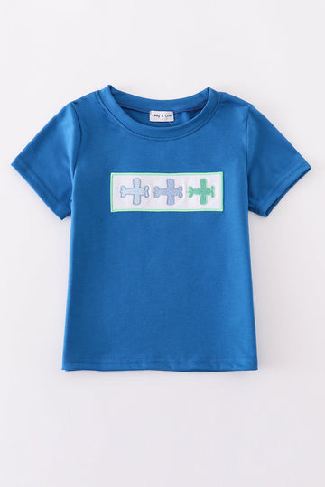 Blue top with playful airplane embroidery, perfect for kids' adventures.