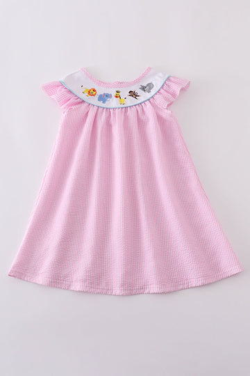 Pink seersucker dress with playful animal embroidery, perfect for spring outings.