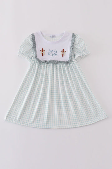 Children's blue dress with "He is Risen" embroidered in white for Easter.