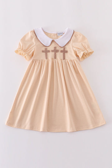Cream dress with delicate cross french knot pattern, perfect for special occasions.