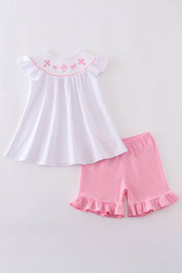 A sweet pink smocked set with delicate cross embroidery, perfect for playdates.