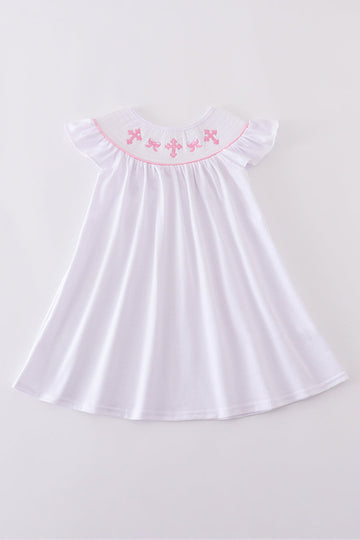 A charming pink dress with cross embroidery and smocked detailing, perfect for playdates.