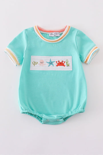 Adorable blue bubble romper with marine creature embroidery and smocked detailing.