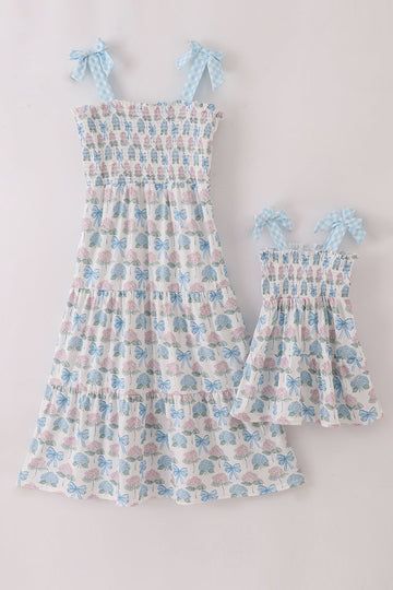 Matching blue hydrangea bow smocked dresses with delicate floral pattern for mom and child.
