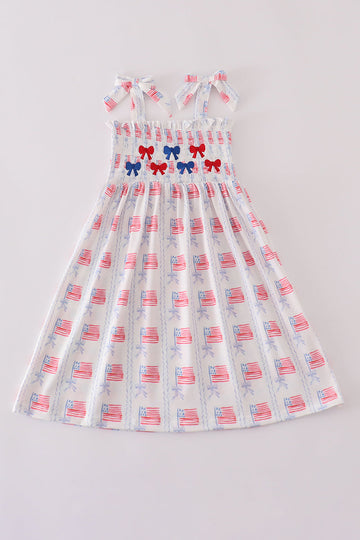 A charming pink smocked dress adorned with delicate bow embroidery, perfect for special occasions.