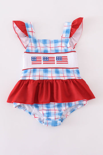 Children’s plaid swimsuit with flag embroidery, smocked details, and UPF50+ protection.