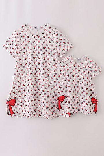 Matching mom and child dresses with playful character print and cute bow details.