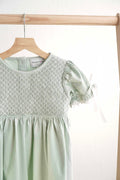 Sage green hand-smocked lace dress with puff sleeves, perfect for special occasions.