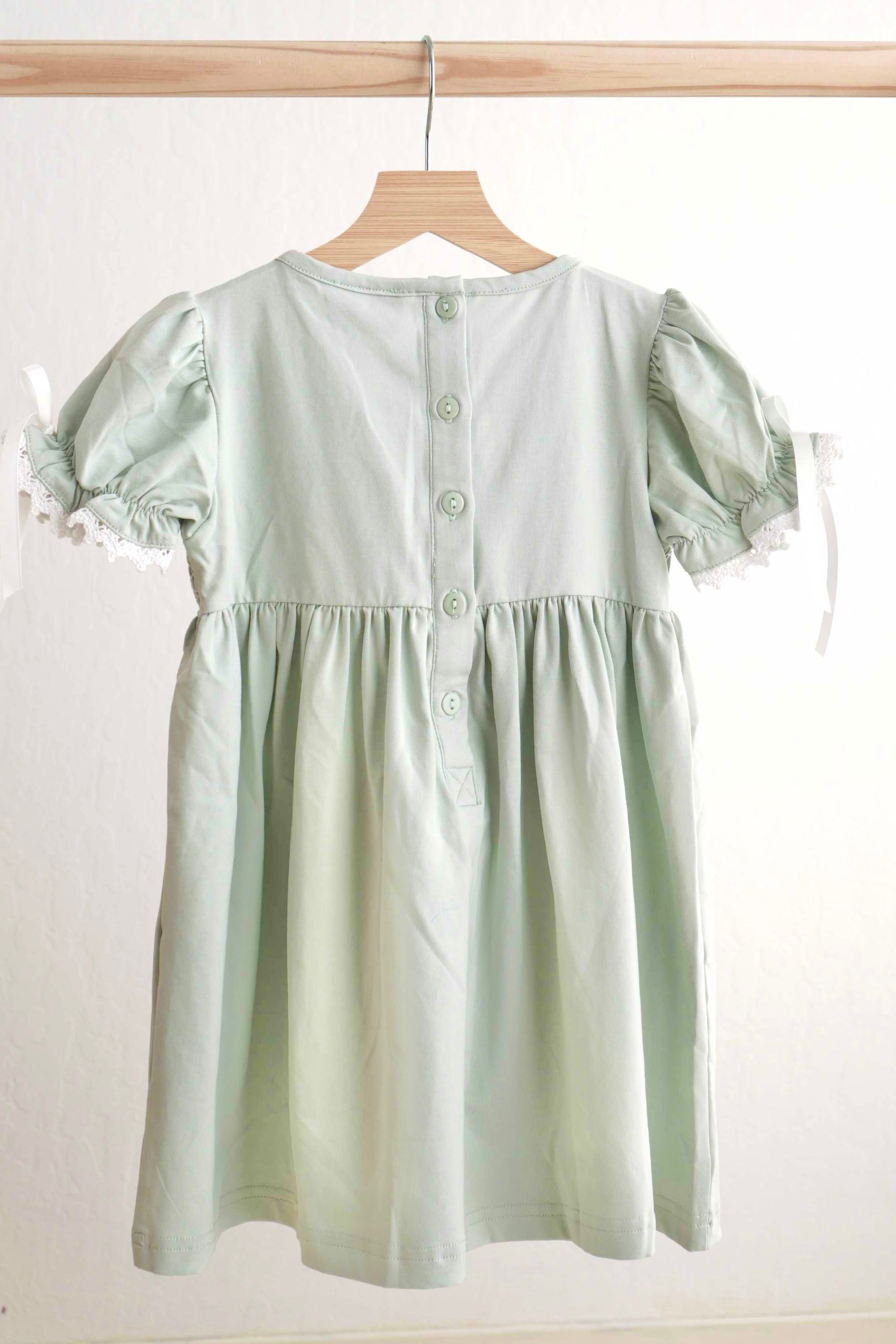 Sage green hand-smocked lace dress with puff sleeves, perfect for special occasions.