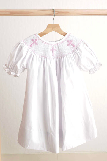 Pink Easter dress with hand-smocked cross pattern, perfect for spring celebrations.