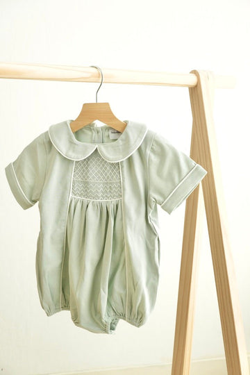 Sage green hand-smocked boy bubble with delicate embroidery, perfect for special occasions.