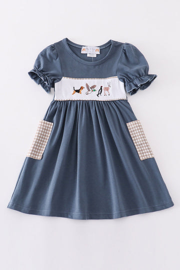 Navy dress with playful hunting embroidery, perfect for adventurous little ones.