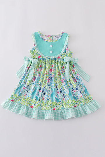 Ocean bloom print ruffle dress with vibrant ocean-themed patterns and playful ruffles.