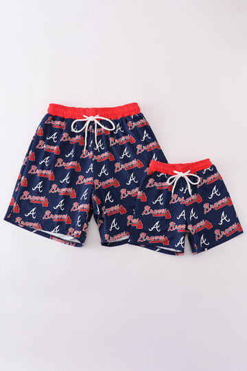 Matching navy swim trunks with Atlanta Braves logo for dad and son.