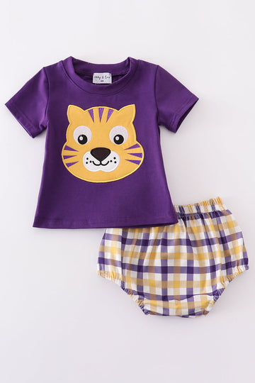 Toddler in a purple and gold LSU bloomer set with ruffled sleeves.