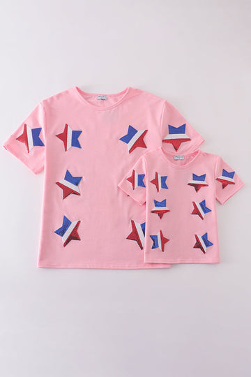 Matching pink tops adorned with shimmering star sequins, perfect for mother-daughter outings.