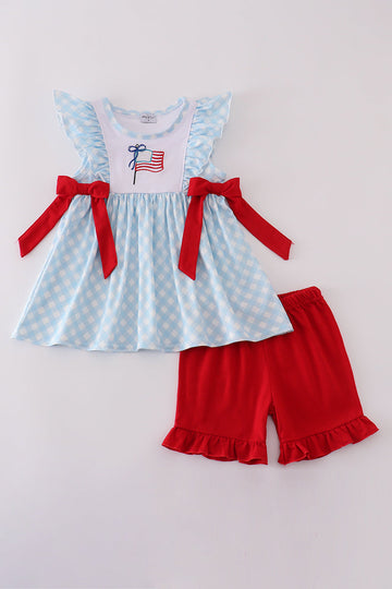 Blue gingham ruffle shorts set with flag embroidery and a matching bow.