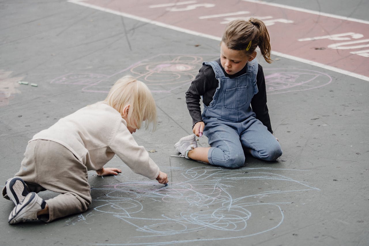 Kids drawing on asphalt outside