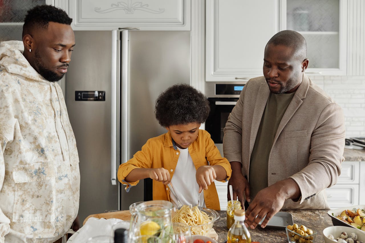 Godparents looking over kid cooking something