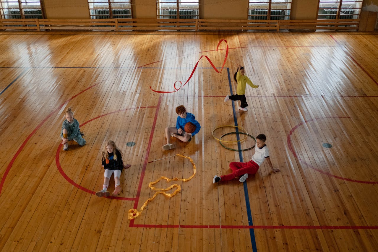 Kids sitting on the basketball court