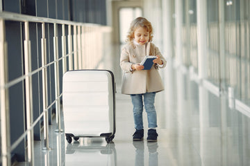 Kid holding her passport in airport corridor