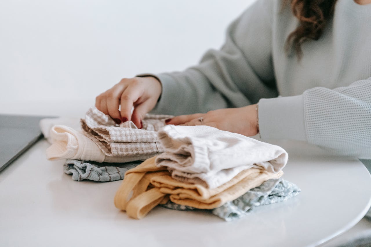 Parent folding baby clothes