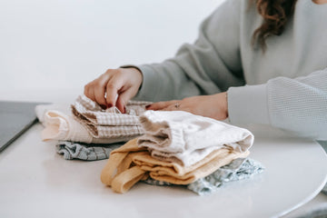 Parent folding baby clothes