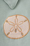 Sage green boy's shirt with delicate sand dollar embroidery, perfect for beach outings.