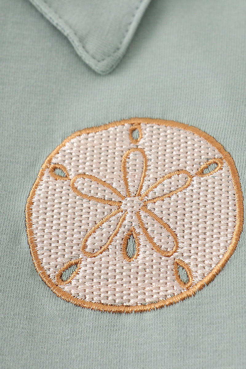 Sage green boy's shirt with delicate sand dollar embroidery, perfect for beach outings.