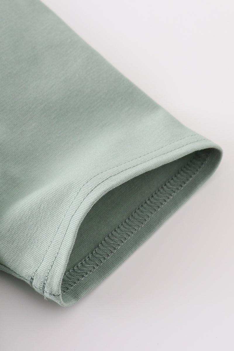 Sage green boy's shirt with delicate sand dollar embroidery, perfect for beach outings.