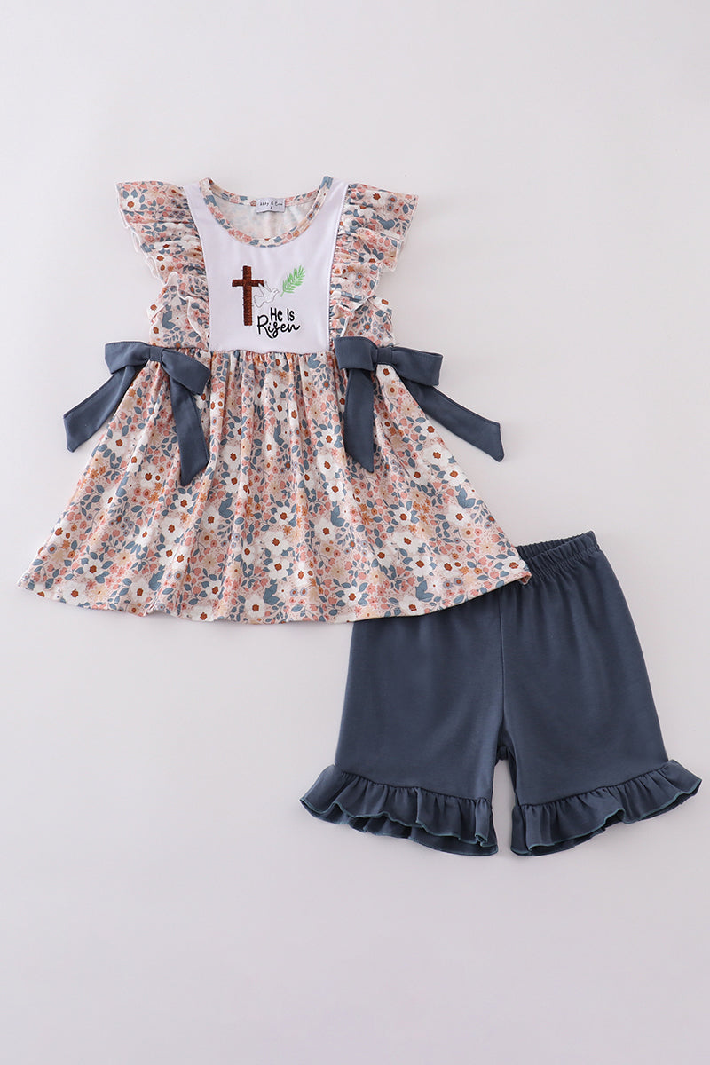 Easter-themed girls' outfit with "He is Risen" embroidery and pastel accents.