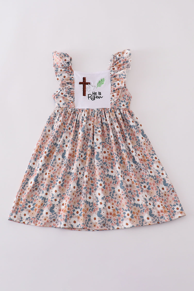 Pink Easter dress with "He is Risen" embroidery and floral accents.