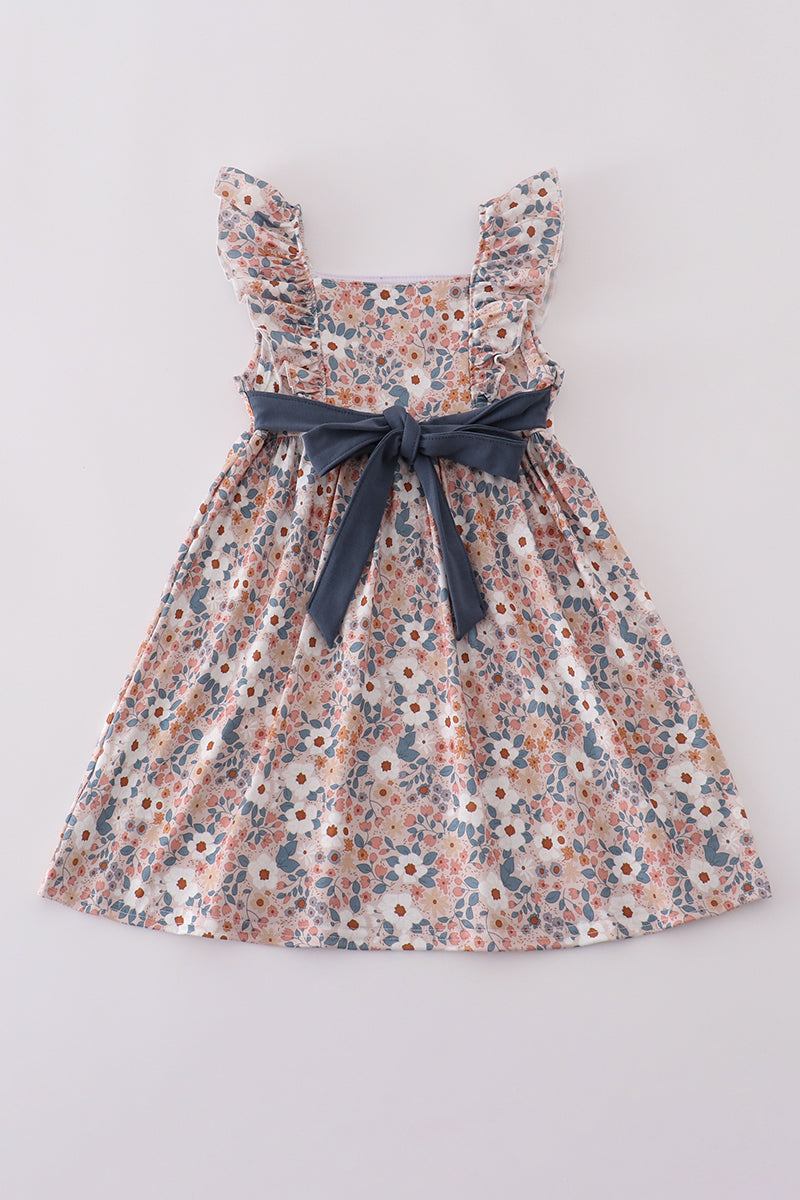 Pink Easter dress with "He is Risen" embroidery and floral accents.