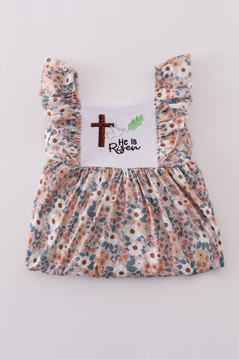 Pink Easter dress with "He is Risen" embroidery and floral accents.