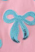 Matching pink tops with sparkly sequin bows, perfect for mom and daughter.