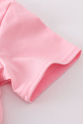 Matching pink tops with sparkly sequin bows, perfect for mom and daughter.