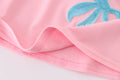 Matching pink sequin dresses with big bows, perfect for mom and daughter.