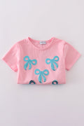 Matching pink sequin dresses with big bows, perfect for mom and daughter.