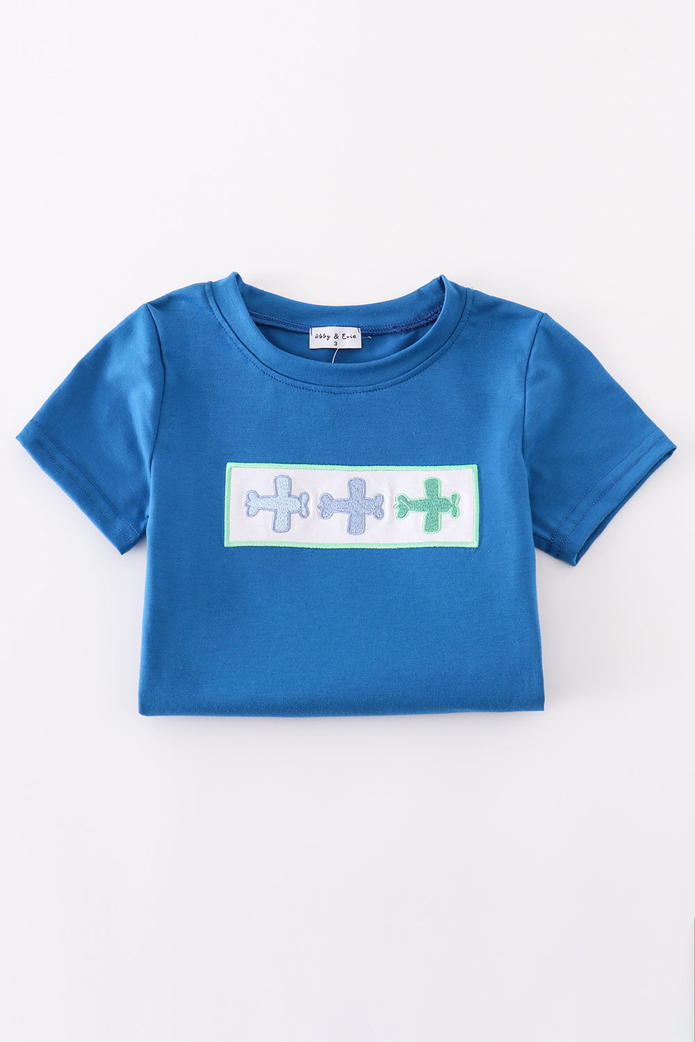 Blue top with playful airplane embroidery, perfect for kids' adventures.