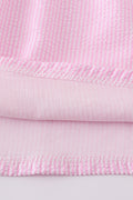 Pink seersucker dress with playful animal embroidery, perfect for spring outings.
