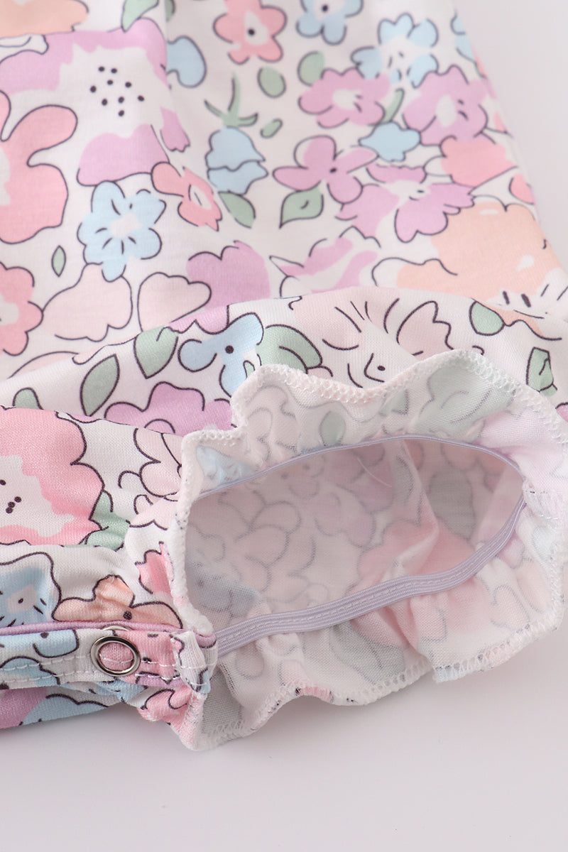 Pink blush bubble romper with a garden bloom print, perfect for spring outings.