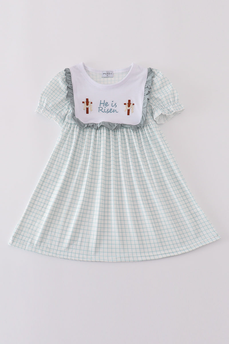 Children's blue dress with "He is Risen" embroidered in white for Easter.