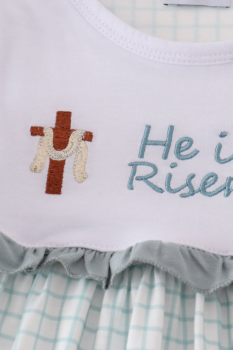 Children's blue dress with "He is Risen" embroidered in white for Easter.