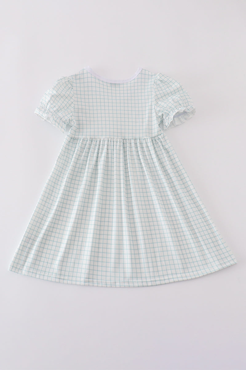 Children's blue dress with "He is Risen" embroidered in white for Easter.