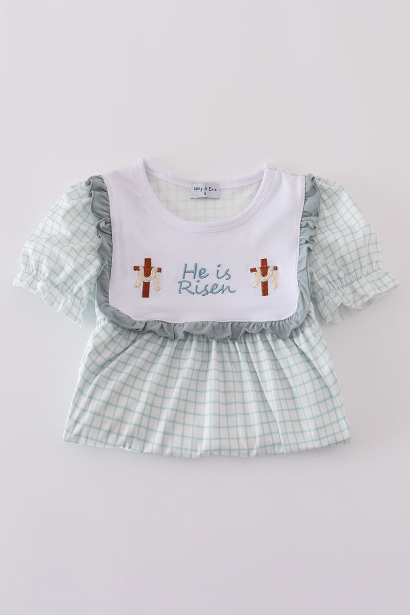 Children's blue dress with "He is Risen" embroidered in white for Easter.